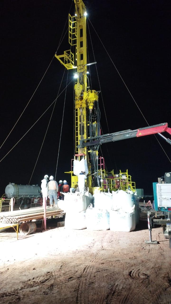 Equipo GeoLift trabajando de noche junto a torre de perforación